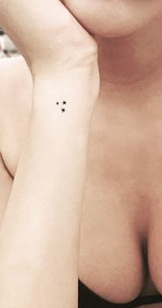three little star tatoo's on a woman's arm
