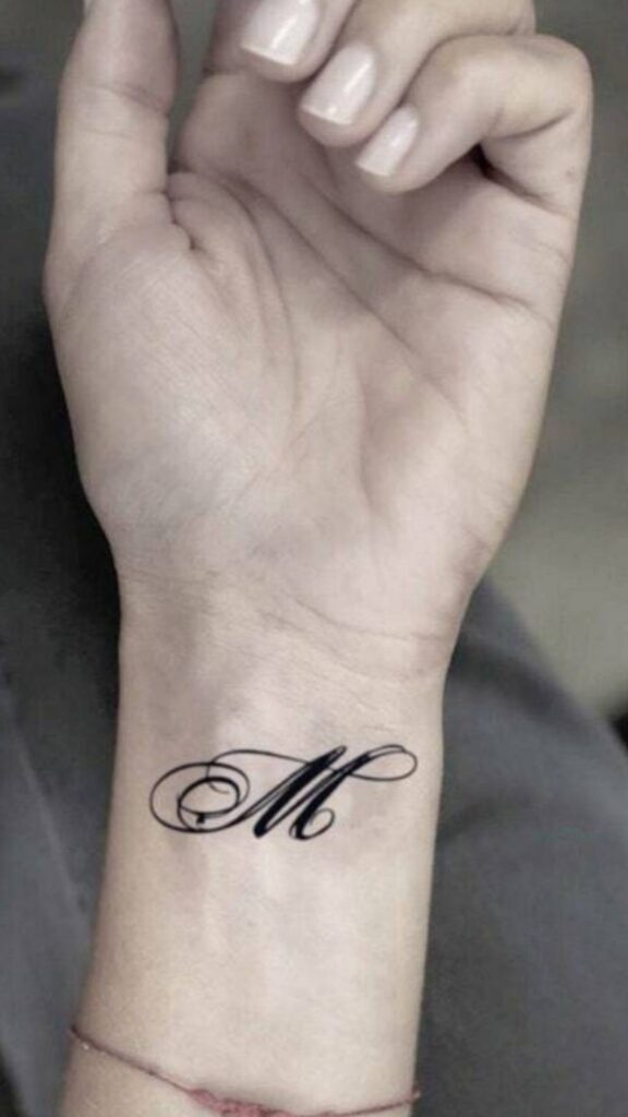 letter M tattoo on a wrist